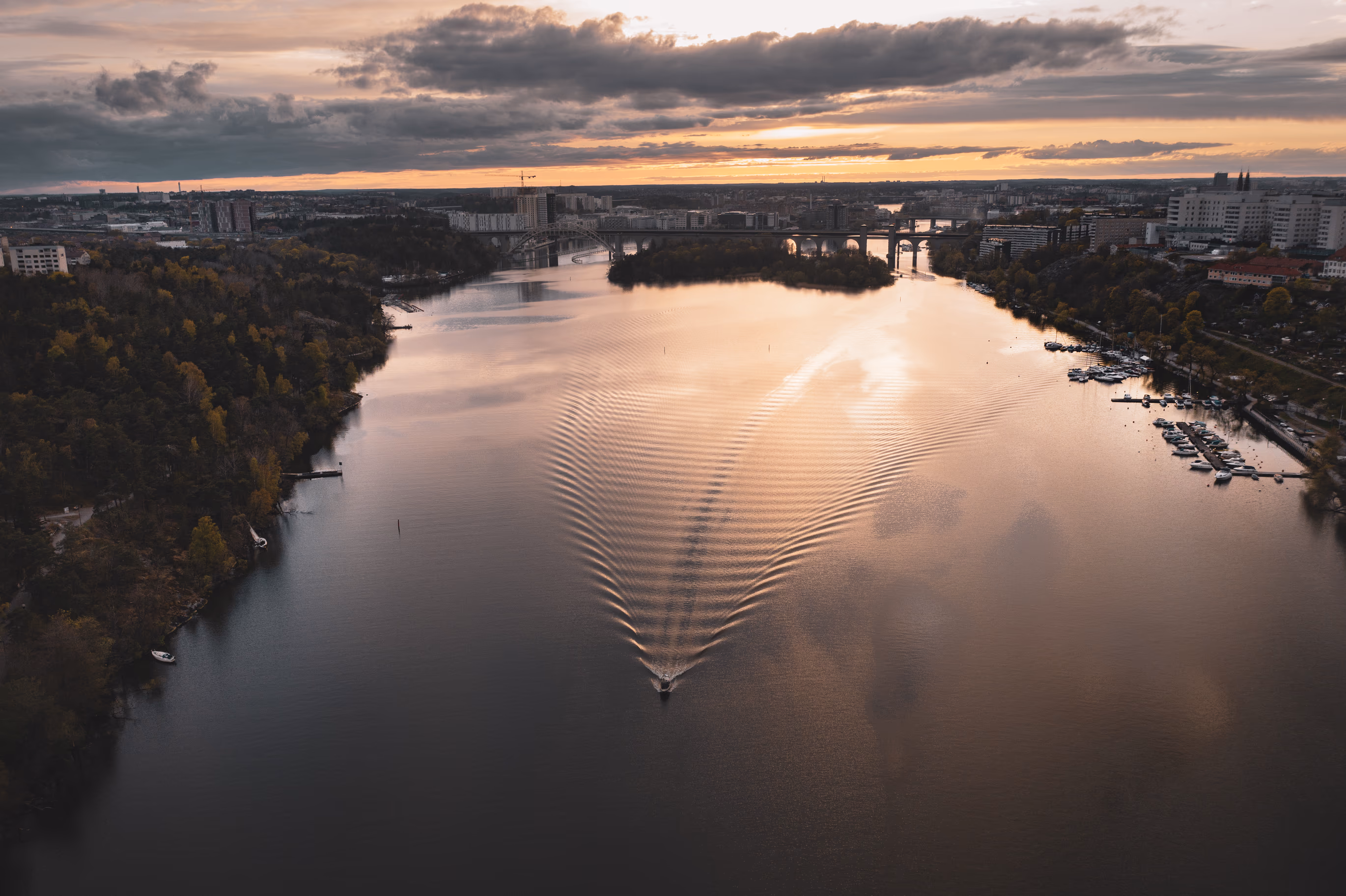 Aerial view of Årstaviken lake in Stockholm at sunset with city skyline